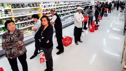 People queueing for a delivery of toilet paper, paper towel and pasta at a Coles supermarket, in March 2020.
