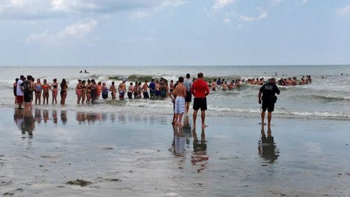 US beachgoers form human chain in desperate attempt to rescue 'distressed' 14-year-old boy