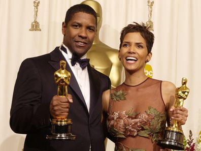 Aktor dan Aktris pemenang Peran Utama Denzel Washington dan Halle Berry berpose dengan Oscar mereka di belakang panggung pada tahun 2002.