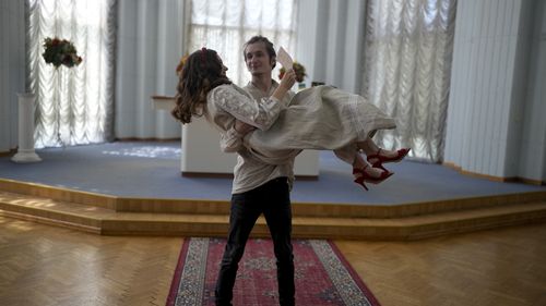 Yevhen Nalyvaiko holds Daria Ponomarenko minutes after getting married in Kyiv, Ukraine.