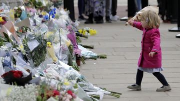 LONDON, ENGLAND - APRIL 09: A young girl lays floral tributes outside Buckingham Palace on April 09, 2021 in London, United Kingdom. The Queen has announced the death of her beloved husband, His Royal Highness Prince Philip, Duke of Edinburgh. HRH passed away peacefully this morning at Windsor Castle. (Photo by John Phillips/Getty Images)