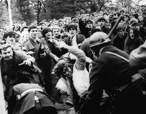 A stick-swinging Madison riot police officer beats back an angry throng of University of Wisconsin protesters, Wednesday, October 19, 1967 on campus. (AAP)