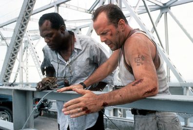 Samuel L Jackson and Bruce Willis standing on a bridge, looking down in a scene from the film 'Die Hard: With a Vengeance', 1995.
