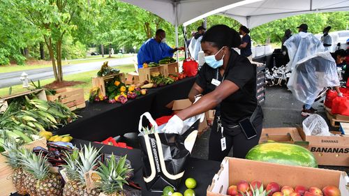 A volunteer prepares a food package during Goodr Pop-Up Grocery Store Shopping Experience at Lucky Shoals Park on May 08, 2020 in Norcross, Georgia. 
