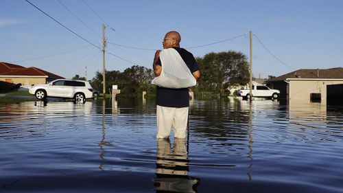 Jean Chatelier walks through a flooded street from Hurricane Irma after retrieving his uniform from his house to return to work today at a supermarket in Fort Myers. (Associated Press)