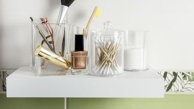 Makeup and other cosmetics on a shelf in a bathroom