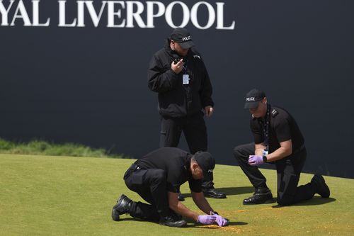 Police clear away debris after protesters threw material onto the 17th green during the second day of the British Open Golf Championships at the Royal Liverpool Golf Club in Hoylake, England, Friday, July 21, 2023 