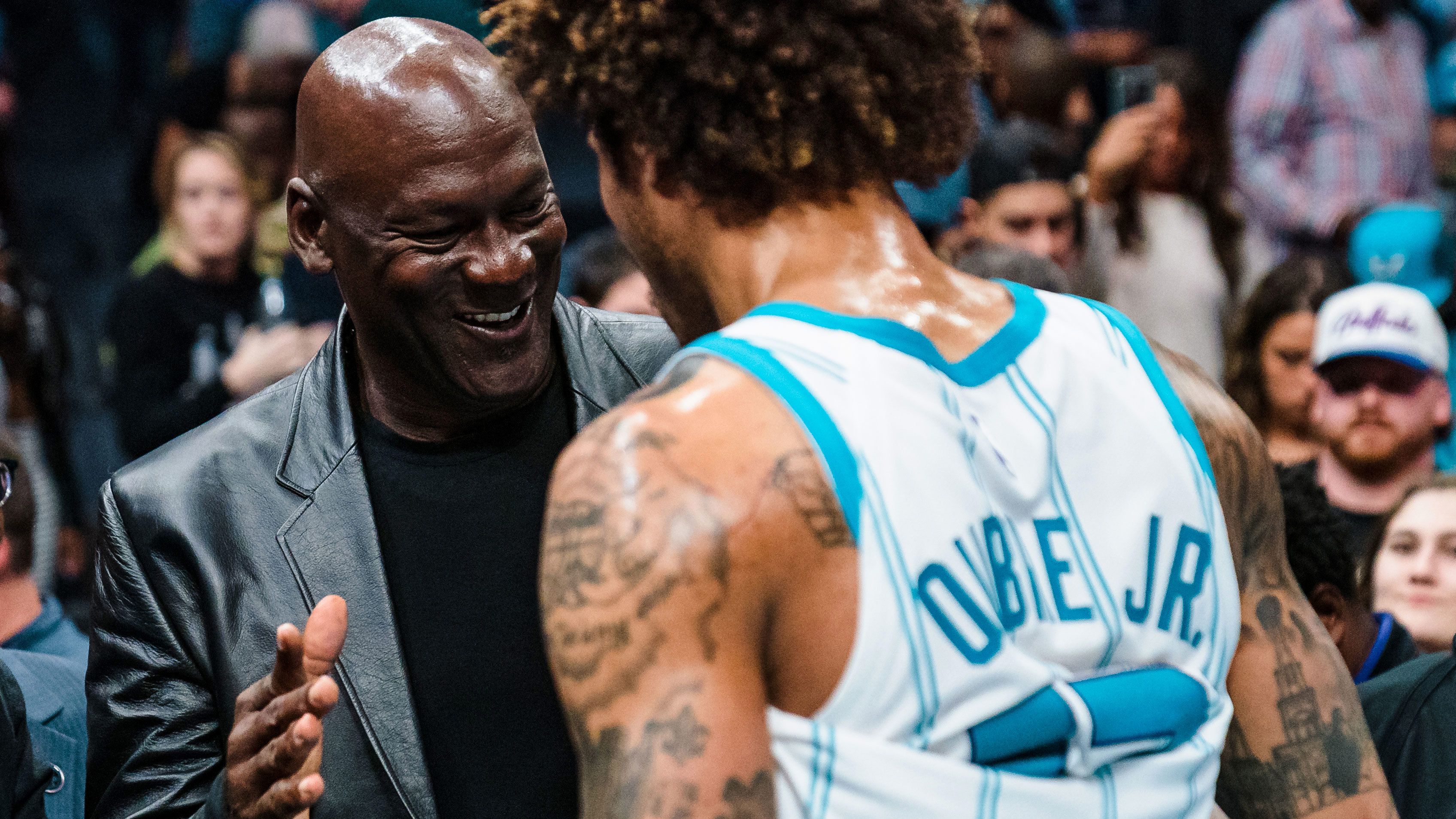 Michael Jordan shakes hands with Kelly Oubre Jr. #12 of the Charlotte Hornets after their game against the Orlando Magic at Spectrum Center on March 03, 2023 in Charlotte, North Carolina.