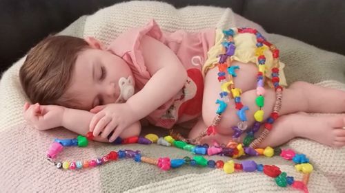 Isabelle Grant, in the photo with a necklace that has a very special meaning.  Each bead represents an important treatment she has undergone in her short life.  There are 160 beads in the necklace.