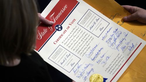 Staff members hold the certification of Electoral College votes from Tennessee