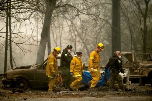 Firefighters recover the body of a Camp Fire victim at the Holly Hills Mobile Estates.