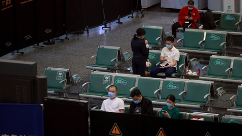 People sit in a temporarily cordoned off area for the relatives of the victims aboard China Eastern's flight MU5735, in Guangzhou Baiyun International Airport in Guangzhou, capital of south China's Guangdong Province, Monday, March 21, 2022