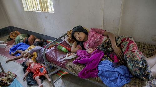 Rohingya women along with their children rest inside a health complex run by aid agencies in Kutupalong refugee camp, Bangladesh. (AAP)