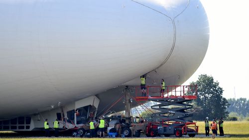 Crews assess the damage to the Airlander 10. (AAP)