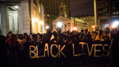 People gather outside the New York Police Department headquarters after marching in the National March Against Police Violence. (Getty)