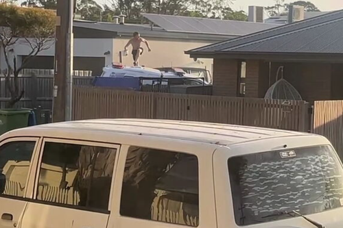 The man was seen leaping from the top of the police car onto the footpath as he fled the scene.