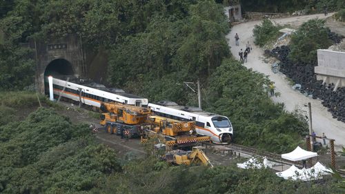 Rescue workers remove a part of the derailed train near Taroko Gorge in Hualien, Taiwan 