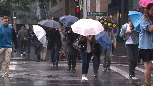 Those who braved the conditions battled to keep a hold on their umbrellas. (AAP)