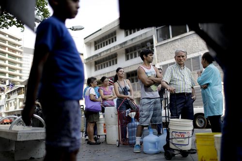 People in Venezuela are forced to line up to get water from limited trucks in Caracas, Venezuela.