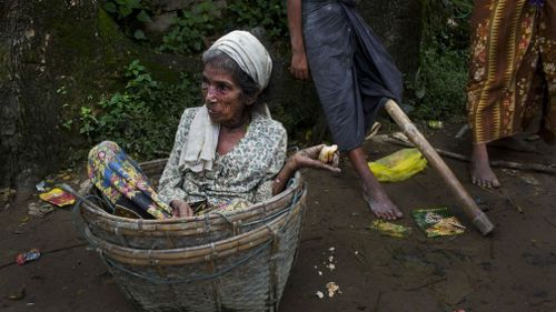 An elderly Rohingya woman sits in a basket that carried her across the border from Myanmar into Bangladesh, after having just arrived at Teknaf border area. (AP)