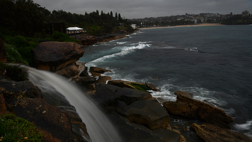 Storm water runs off the cliffs behind Wiley's Baths in Coogee today after a cold weather front passing through Sydney lowed the temperatures by 10 degrees or more and brought Rain with it.