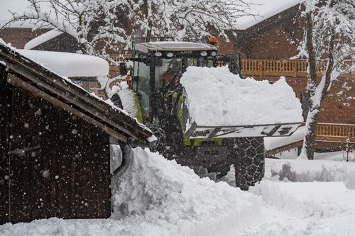 A tractor removes piles of snow after heavy snowfall. 