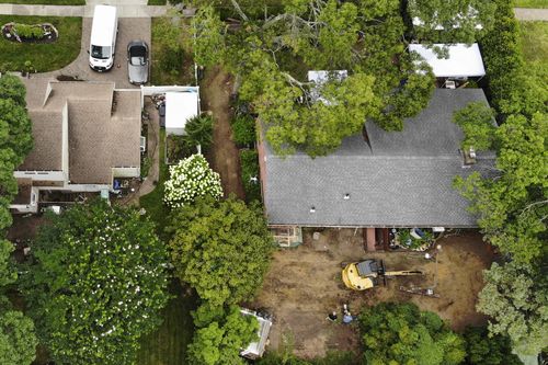 Authorities continue to work at the home of suspect Rex Heuermann, bottom right, in Massapequa Park, N.Y.