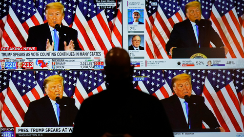 A live broadcast of President Donald Trump speaking from the White House is shown on screens at an election-night party, Tuesday, Nov. 3, 2020, in Las Vegas. (AP Photo/John Locher)