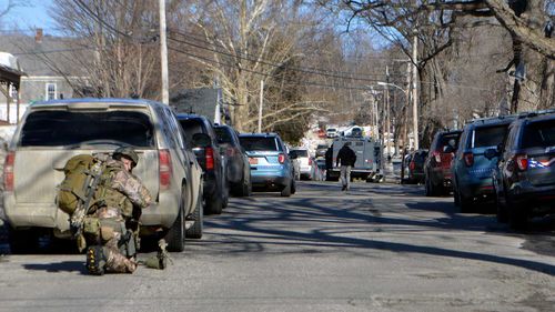 A member of the Maine State Police tactical team gears up in Livermore Falls, Maine.