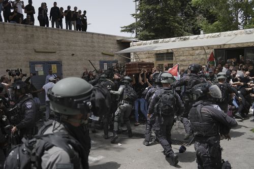 Israeli police confront with mourners as they carry the casket of slain Al Jazeera veteran journalist Shireen Abu Akleh during her funeral in east Jerusalem, Friday, May 13, 2022. Abu Akleh, a Palestinian-American reporter who covered the Mideast conflict for more than 25 years, was shot dead Wednesday during an Israeli military raid in the West Bank town of Jenin. (AP Photo/Mahmoud Illean)