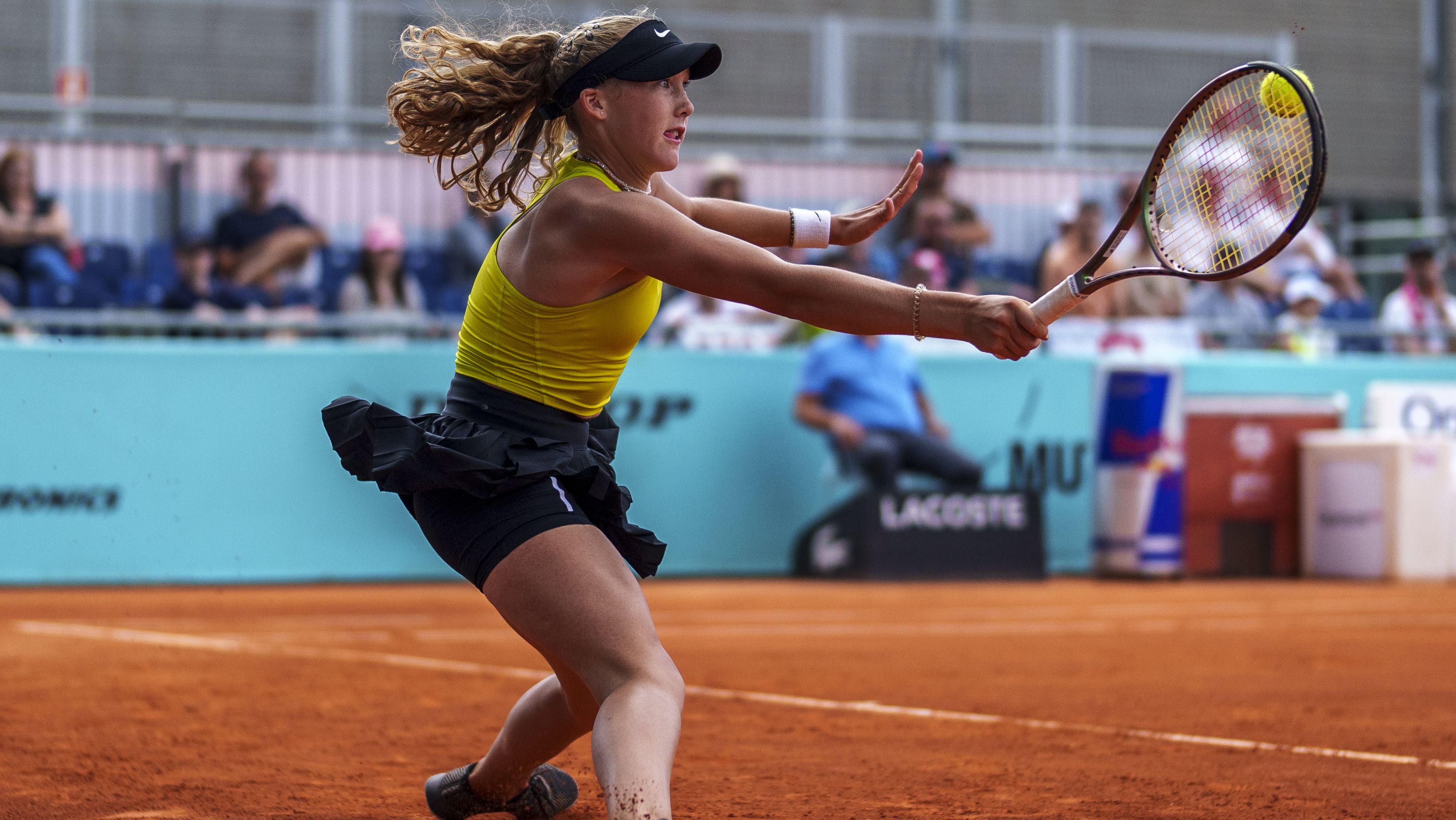 Mirra Andreeva of Russia returns the ball against Magda Linette of Poland at the Madrid Open.