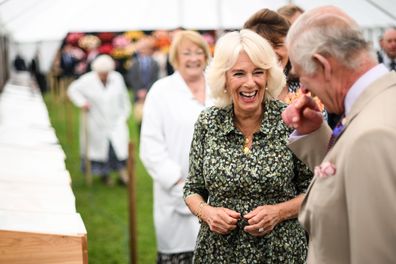 King Charles III and Queen Camilla laugh during a visit to the Sandringham Flower Show at Sandringham House on July 26, 2023 in King's Lynn, England.  