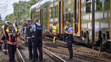 Police officers standing in front of a regional train in Herzogenrath, Germany, Friday, May 13, 2022. 