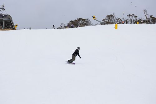 A snowboarder carves fresh snow on Perisher.