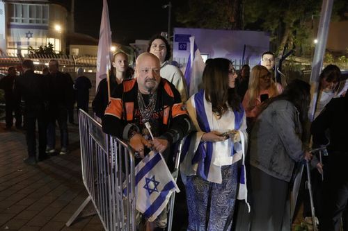 People wait for the arrival of the coffin with remains of Israeli hostage Ran Gvili, last to be recovered from Gaza, to the Abu Kabir Forensic Institute in Tel Aviv, Israel