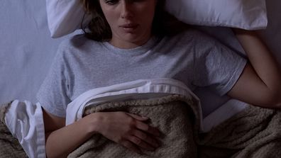 Upset female awakening in bed, disappointed with bad dream, suffering nightmares