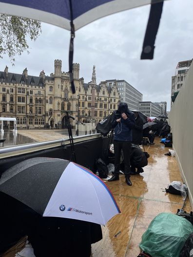 Journalists and photographers on the rained out QEII stand opposite Westminster Abbey for the coronation