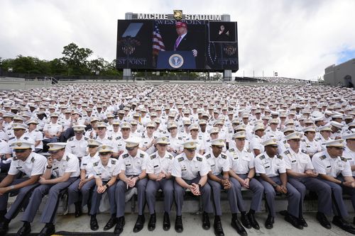 Cadets listen as President Donald Trump, seen on screen, speaks to United States Military Academy graduating cadets