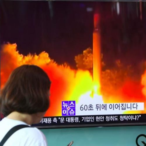 Passers-by on edge in Japan watch television coverage after North Korea launched a missile over the country. 