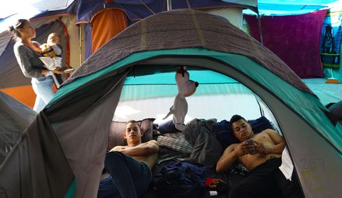 Sergio Alcides Castro Palacios (left) and his brother, Darwin Alcides Castro Palacios (right) relax in their tent at the El Barretal migrant shelter in Tijuana. The two brothers arrived in Tijuana in November as members of the migrant caravan travelling from Honduras. 