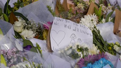 A note is attached to flowers at a tribute near a crime scene at Bondi Junction in Sydney, Monday, April 15, 2024, after several people were stabbed to death at a shopping, Saturday April 13. Australian police are examining why a lone assailant who stabbed multiple people to death in a busy Sydney shopping mall and injured more than a dozen others targeted women while avoiding men. (AP Photo/Mark Baker)