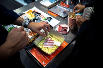 People prepare instant noodles before cooking at the Good Noodle store in Bangkok, Thailand, March 21, 2022.   