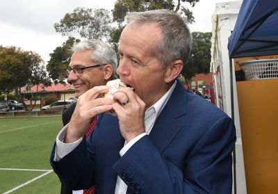Federal Opposition leader Bill Shorten enjoying a democracy sausage after voting at Moonee Ponds West Primary School in Melbourne.