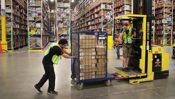 Workers pack customer orders at an Amazon fulfillment centre.