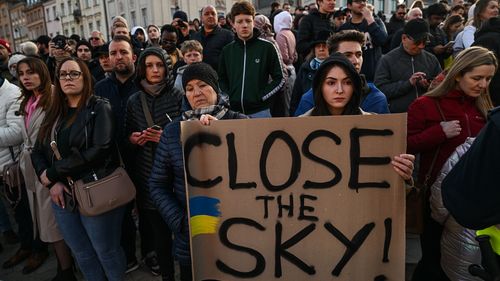 People wait ahead of The US President, Joe Biden delivering a speech at the Royal Castle on March 26, 2022 in Warsaw, Poland. 