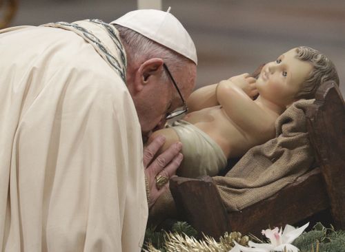 Pope Francis kisses a statue of the Divine Infant as he celebrates a new year's eve vespers Mass in St. Peter's Basilica at the Vatican, Sunday, Dec. 31, 2017.  (AAP)