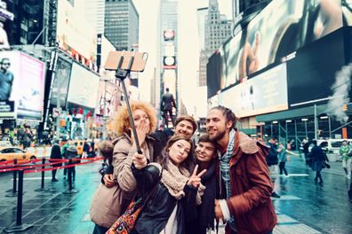 Group of friends making selfie in Time Square