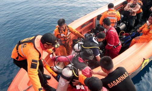 Indonesian navy divers search for the black box flight recorder today.