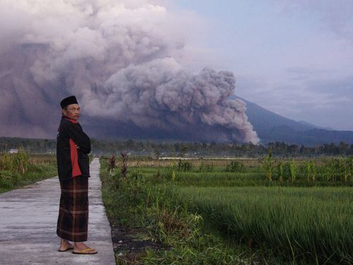 A man looks on as Mount Semeru releases volcanic materials during an eruption on Sunday, in Lumajang, East java, Indonesia.