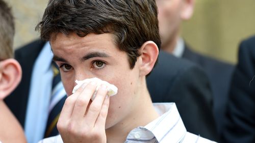 Cain, the son of NSW police officer Bryson Anderson, wipes his eyes as he leaves NSW Court of Criminal Appeal in Sydney today. 